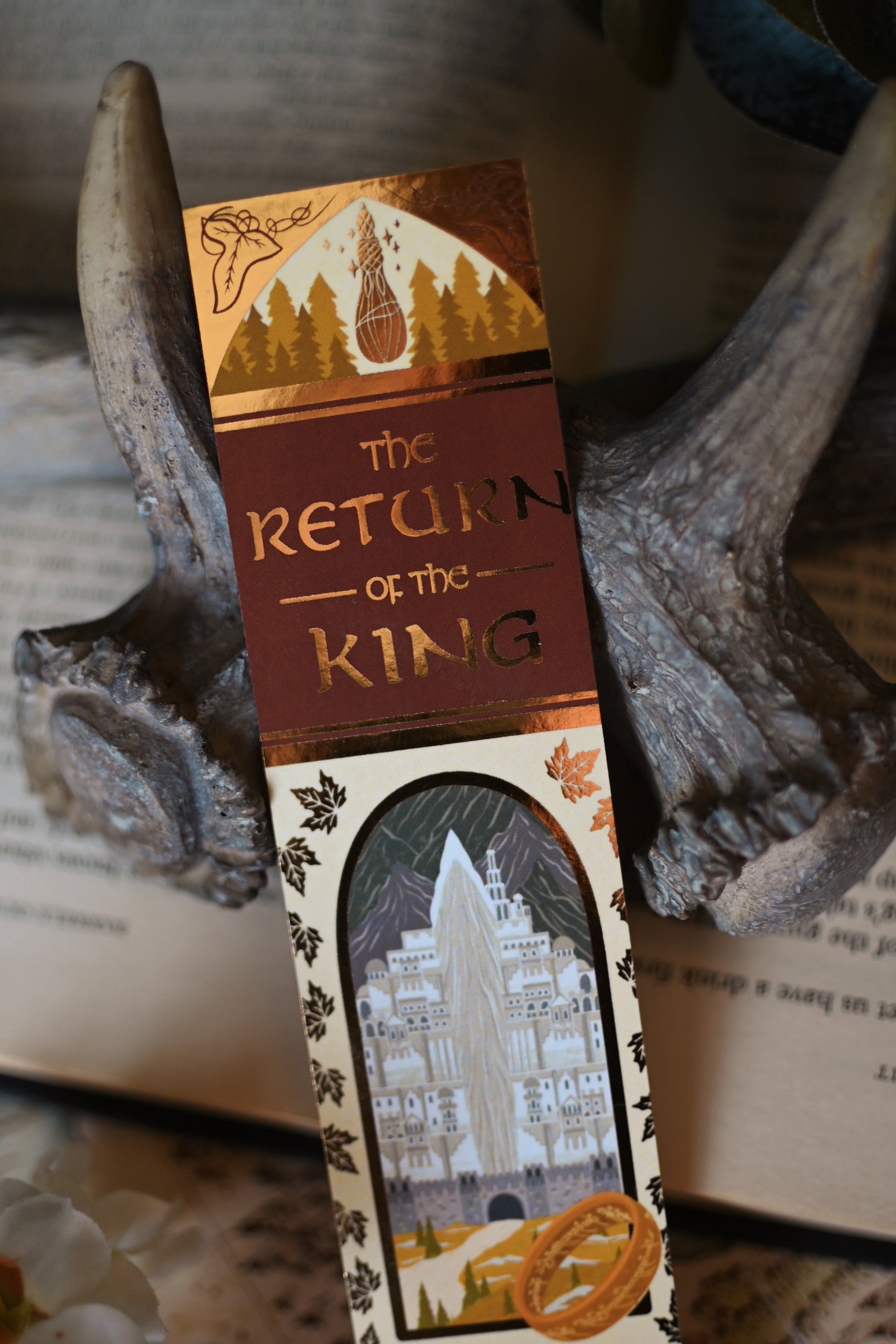A close up image of The Return of the King reimagined book spin bookmark showcasing the title and gold detailing of the bookmarks.